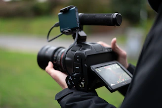 Close-up of hands holding a camera with a video review playing on screen