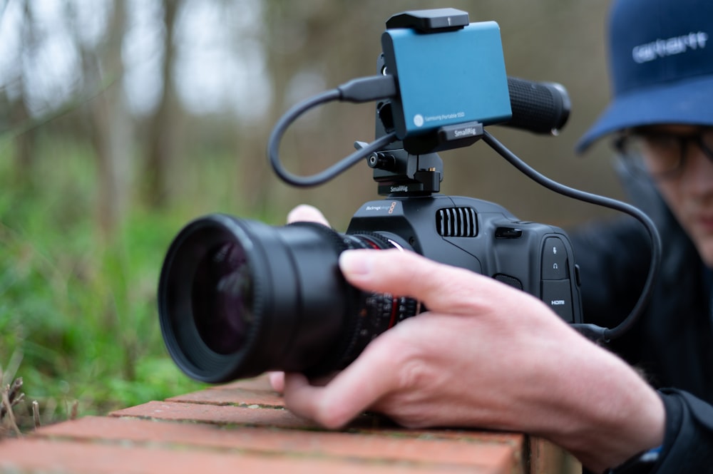 person holding black dslr camera