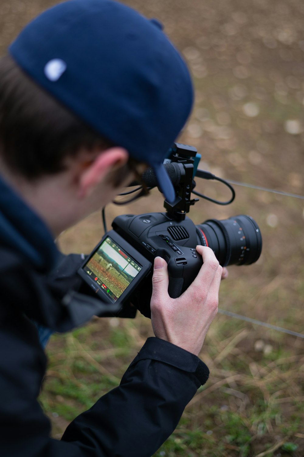 Mann in blauer Jacke mit schwarzer DSLR-Kamera