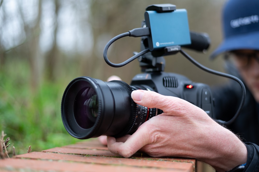 person holding black dslr camera