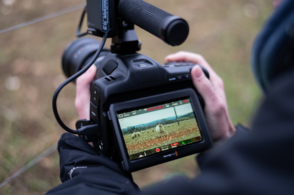 Person mit schwarzer DSLR-Kamera