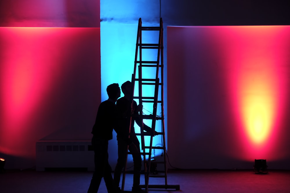 man in black jacket standing on black ladder