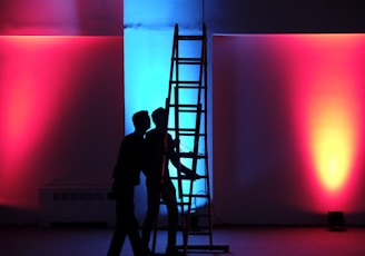 man in black jacket standing on black ladder