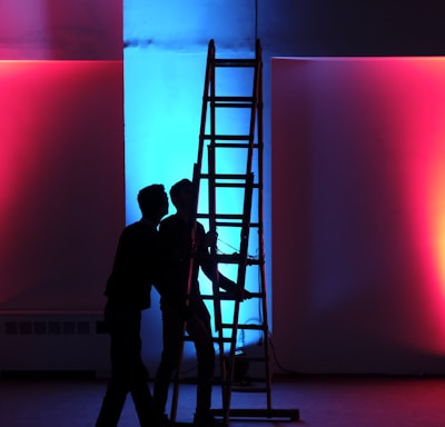 man in black jacket standing on black ladder