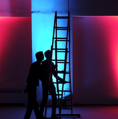 man in black jacket standing on black ladder