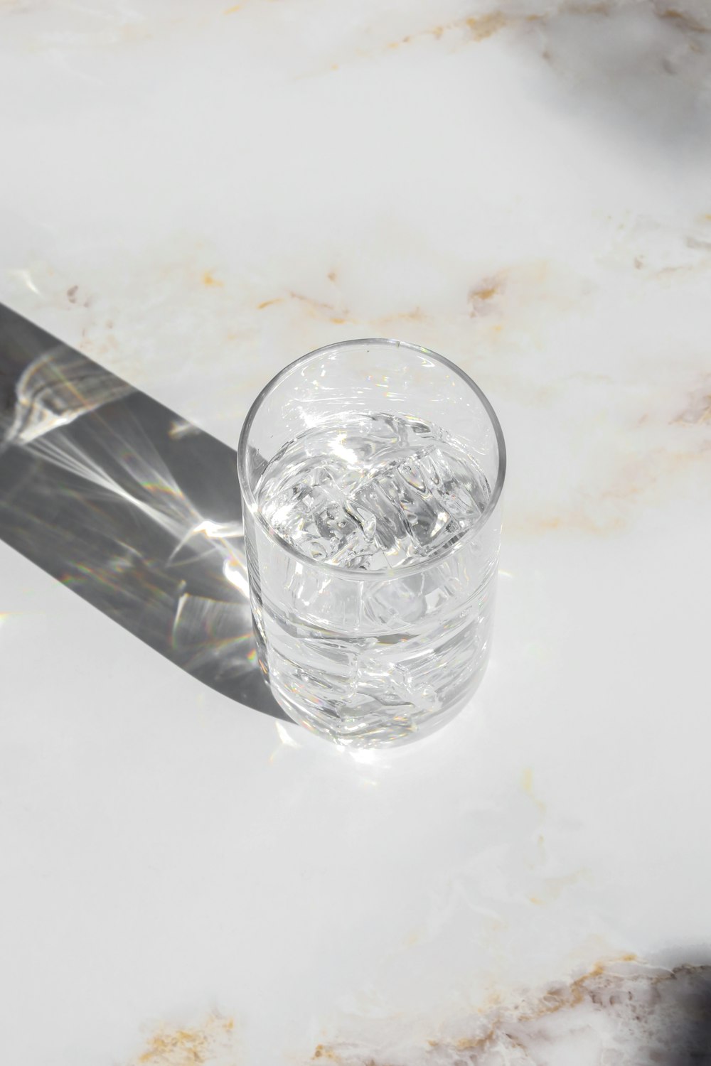 bicchiere trasparente sul tavolo bianco