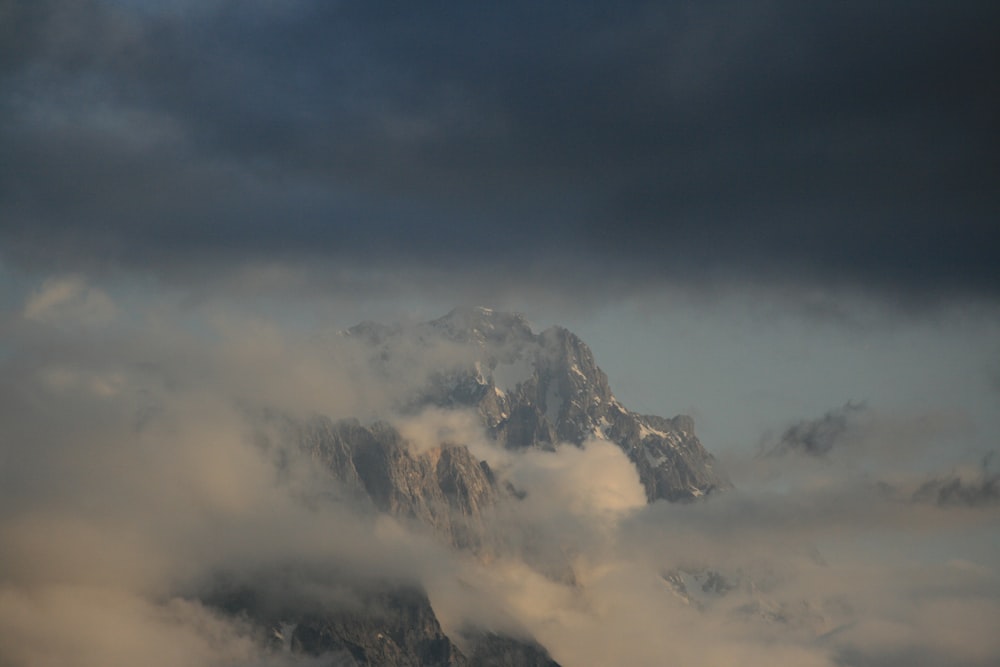 white clouds over snow covered mountain