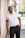 man in white polo shirt and black pants standing beside white wall during daytime