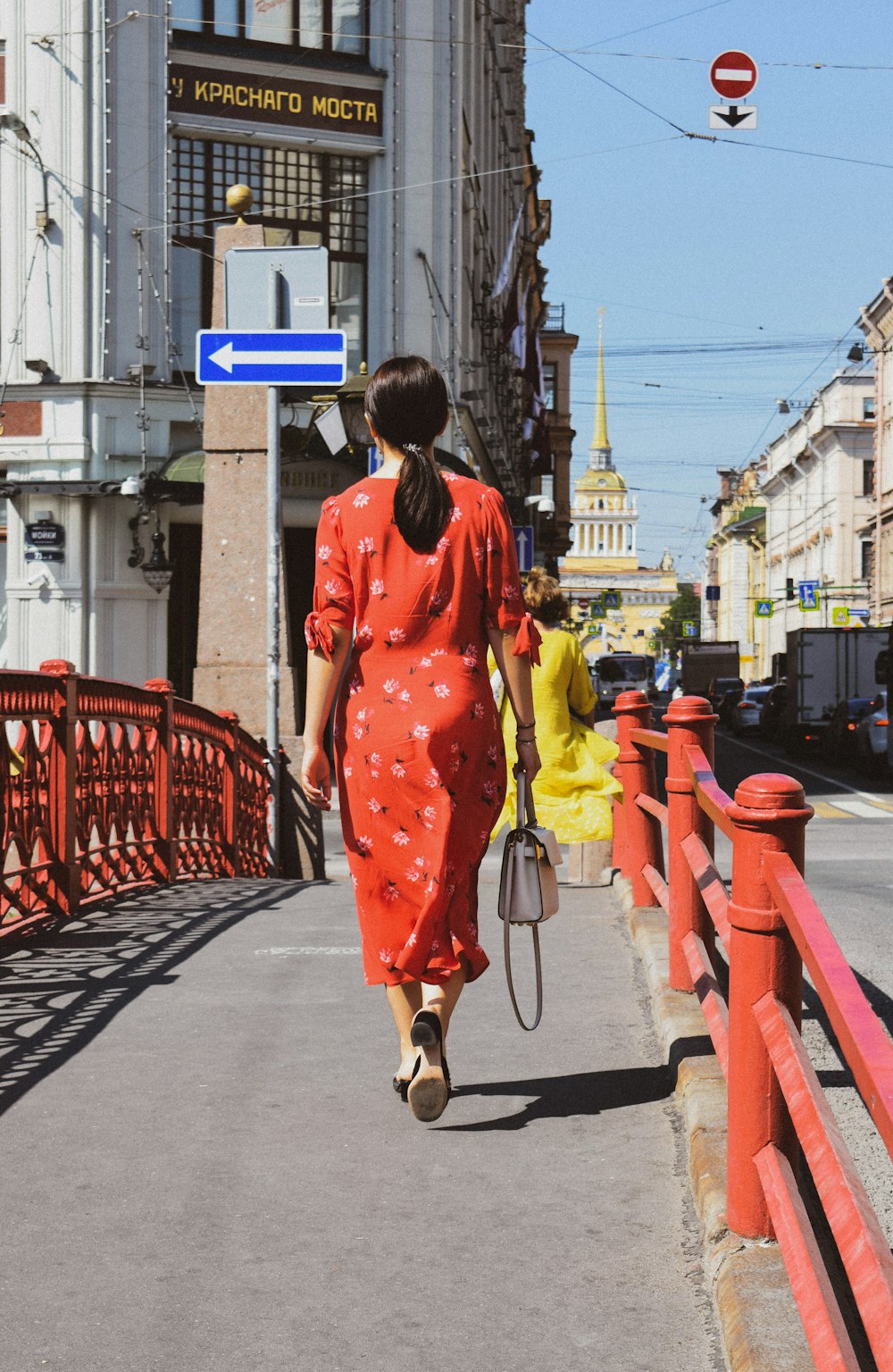 woman in red and white polka dot robe walking on sidewalk during daytime