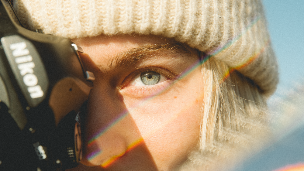 Frau mit weißer Strickmütze und schwarzer Sonnenbrille