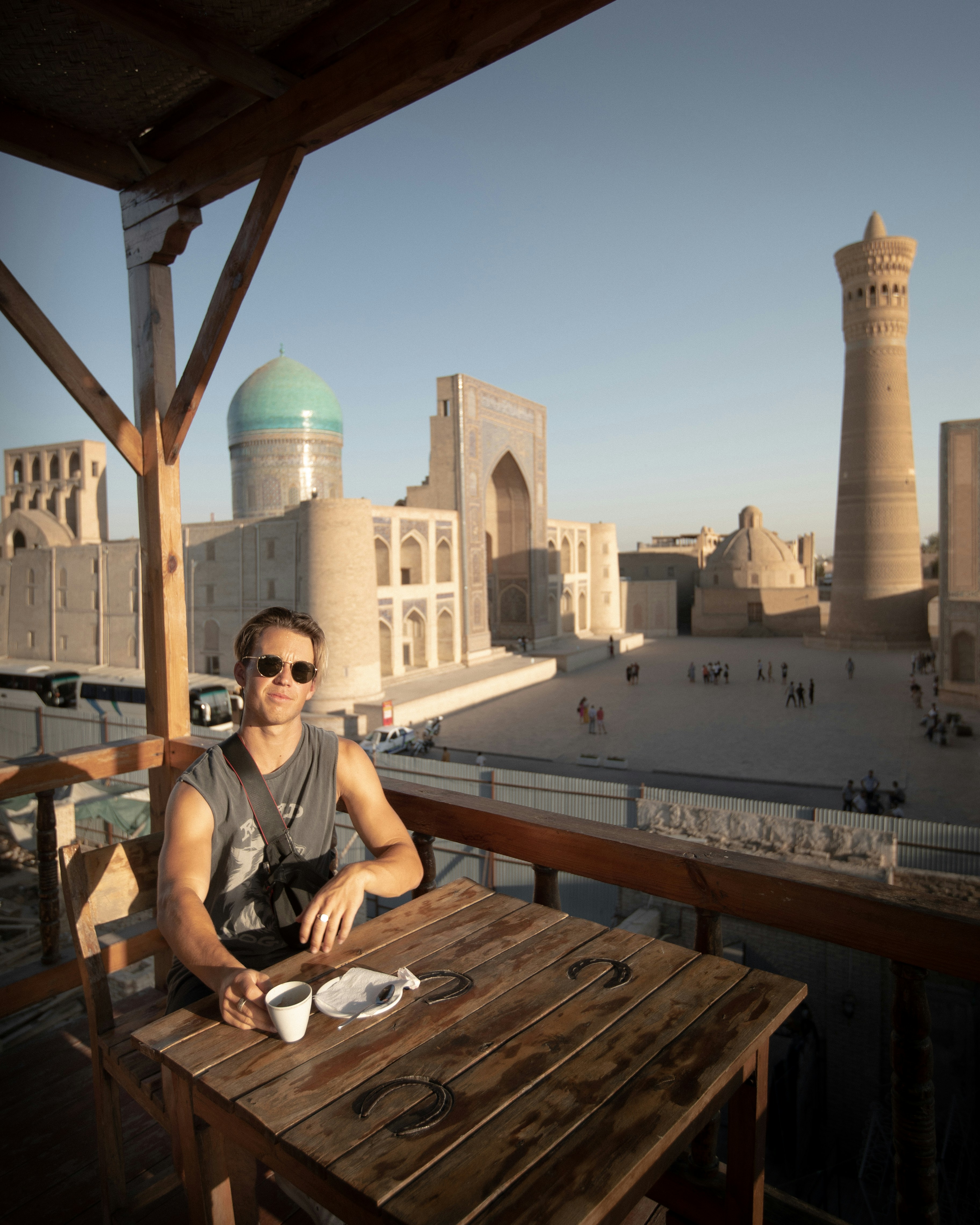 woman in black tank top sitting on brown wooden bench