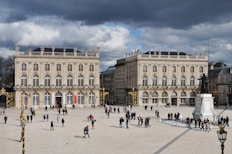 people walking around white concrete building during daytime