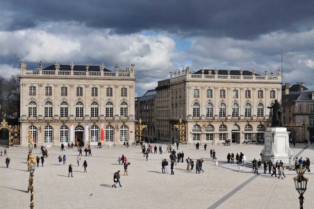 people walking around white concrete building during daytime