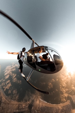 man in black jacket and blue denim jeans riding on black and yellow swing during daytime