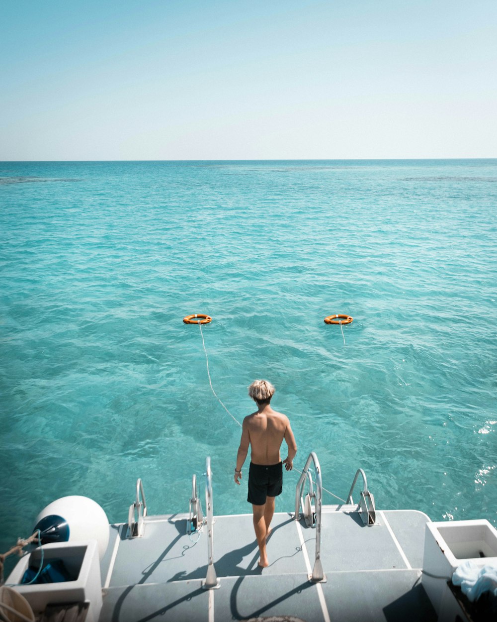 man in blue shorts on white boat during daytime