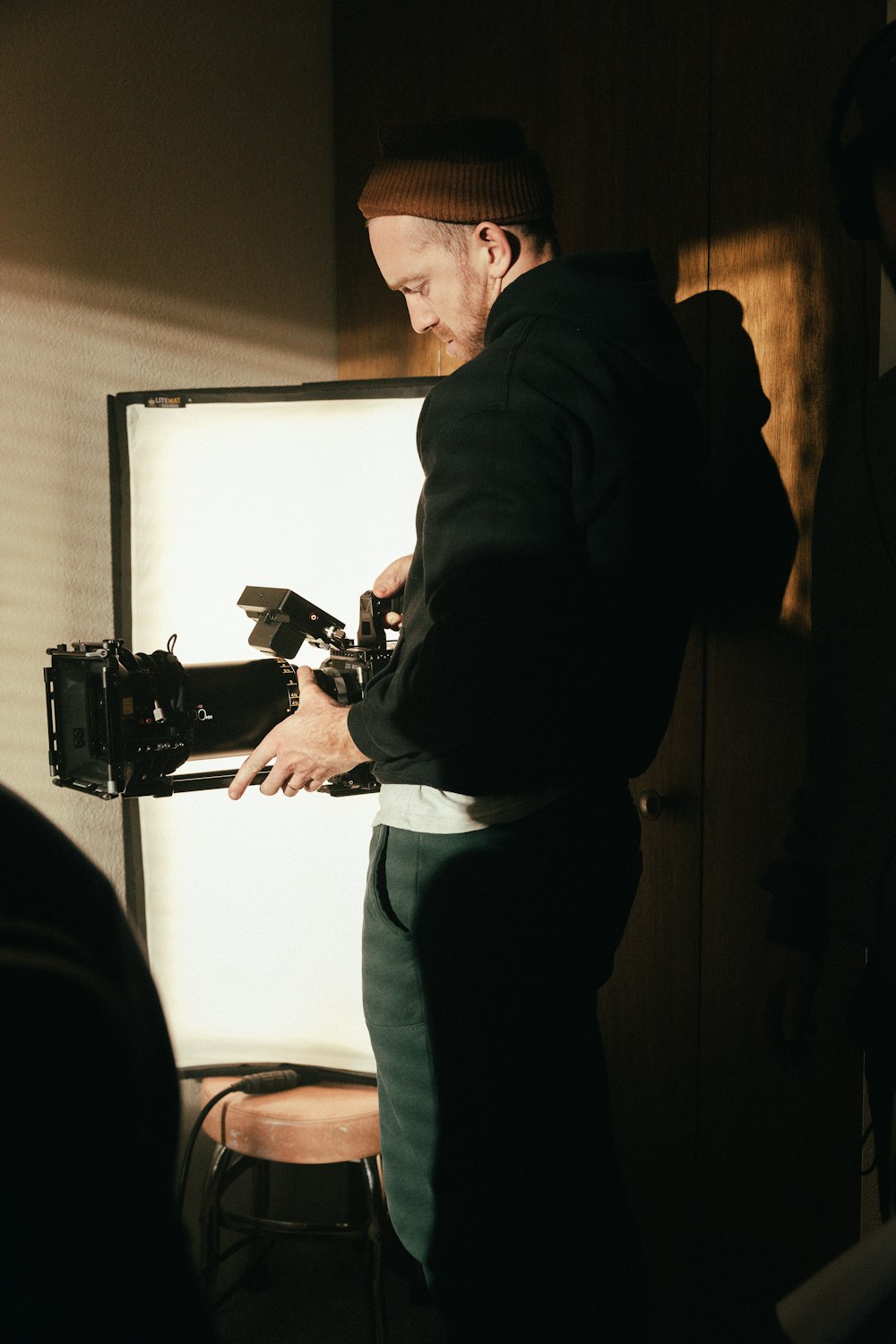 man in black jacket and gray pants holding black video camera