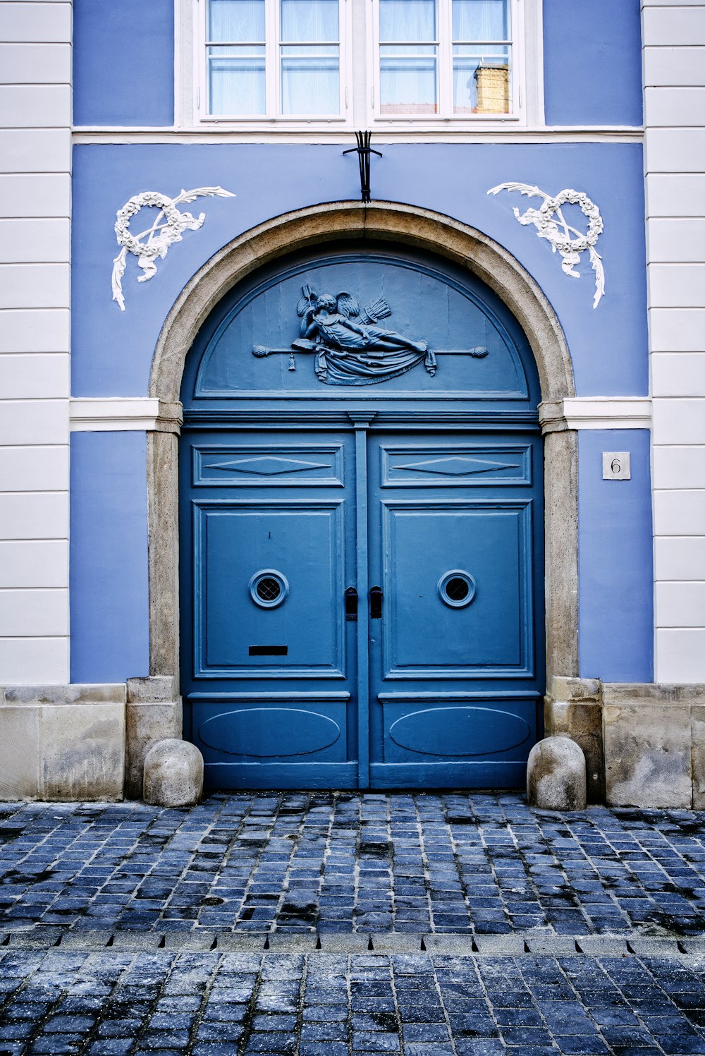 blue wooden door on white concrete building