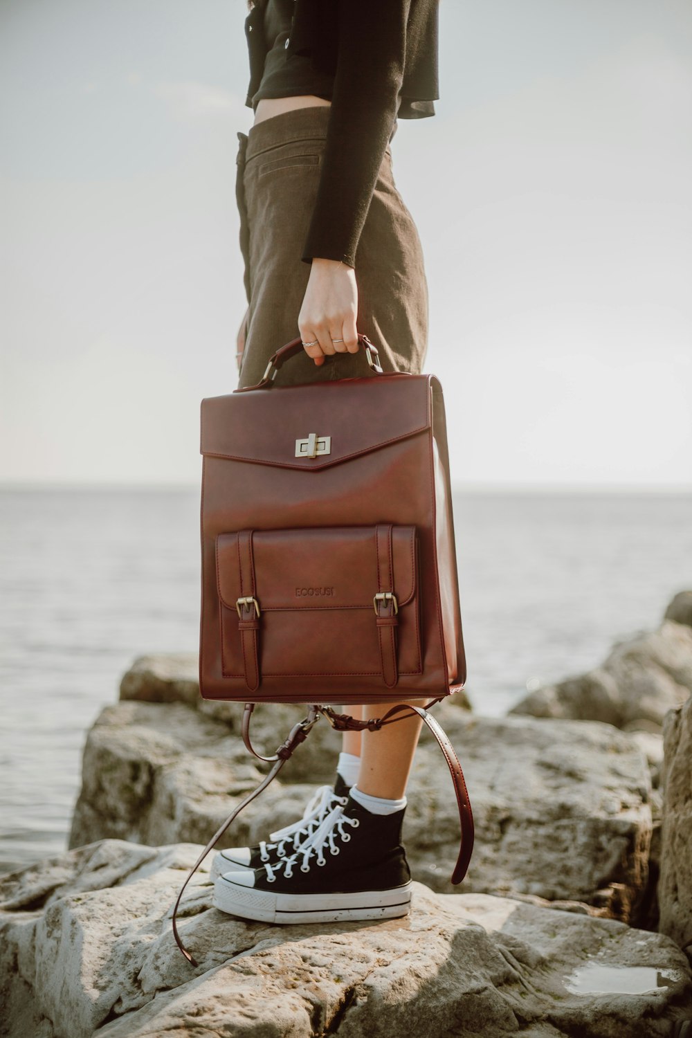 woman in brown coat carrying brown leather handbag