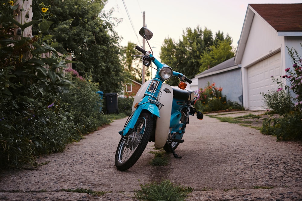 blue and black motorcycle parked on gray concrete pavement