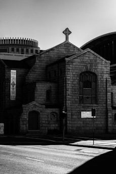 A serene black and white image of the church building with gold accents on the entrance.