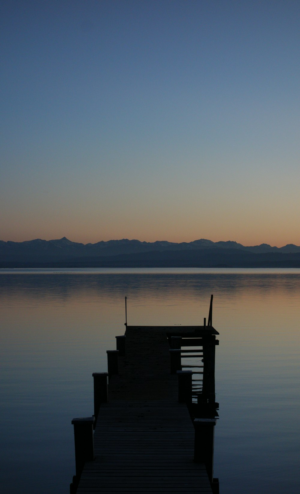 silhouette of a dock on a lake