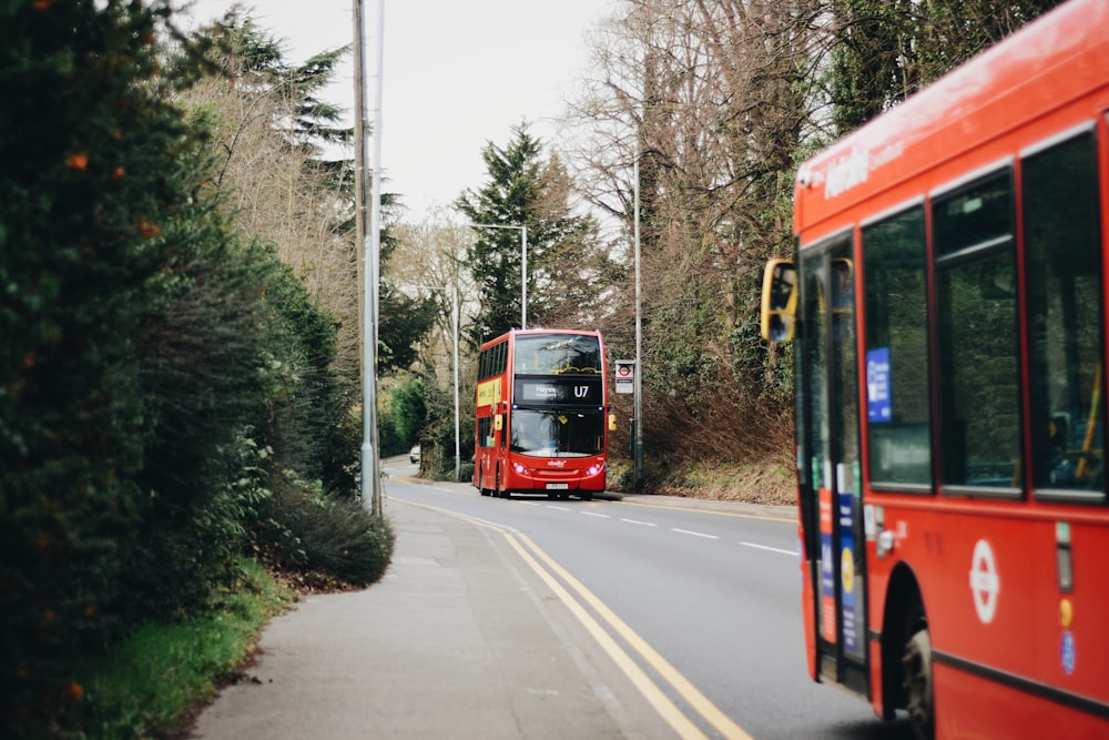 昼間の道路を走る赤と白のバス