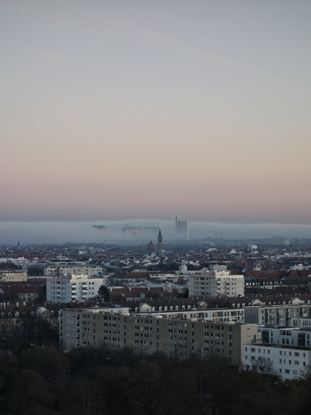 city with high rise buildings under white sky during daytime