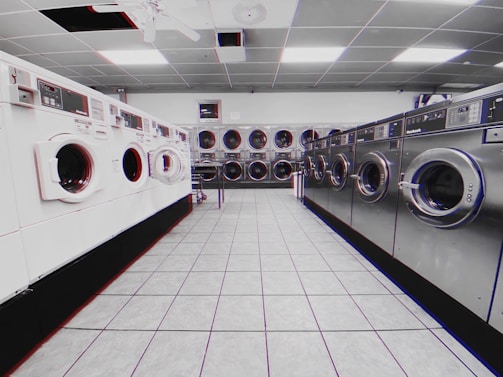 Bright and tidy laundromat interior with washing machines and customers using self-service machines.