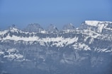 Wide panoramic view of rugged mountain ridges dusted with snow.