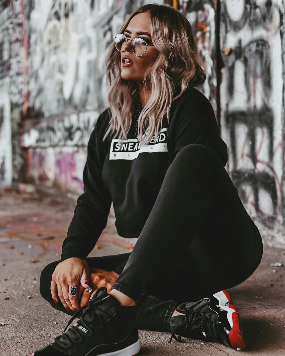 woman in black jacket and black pants sitting on ground