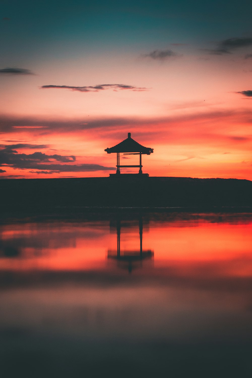 silhouette of person standing on dock during sunset