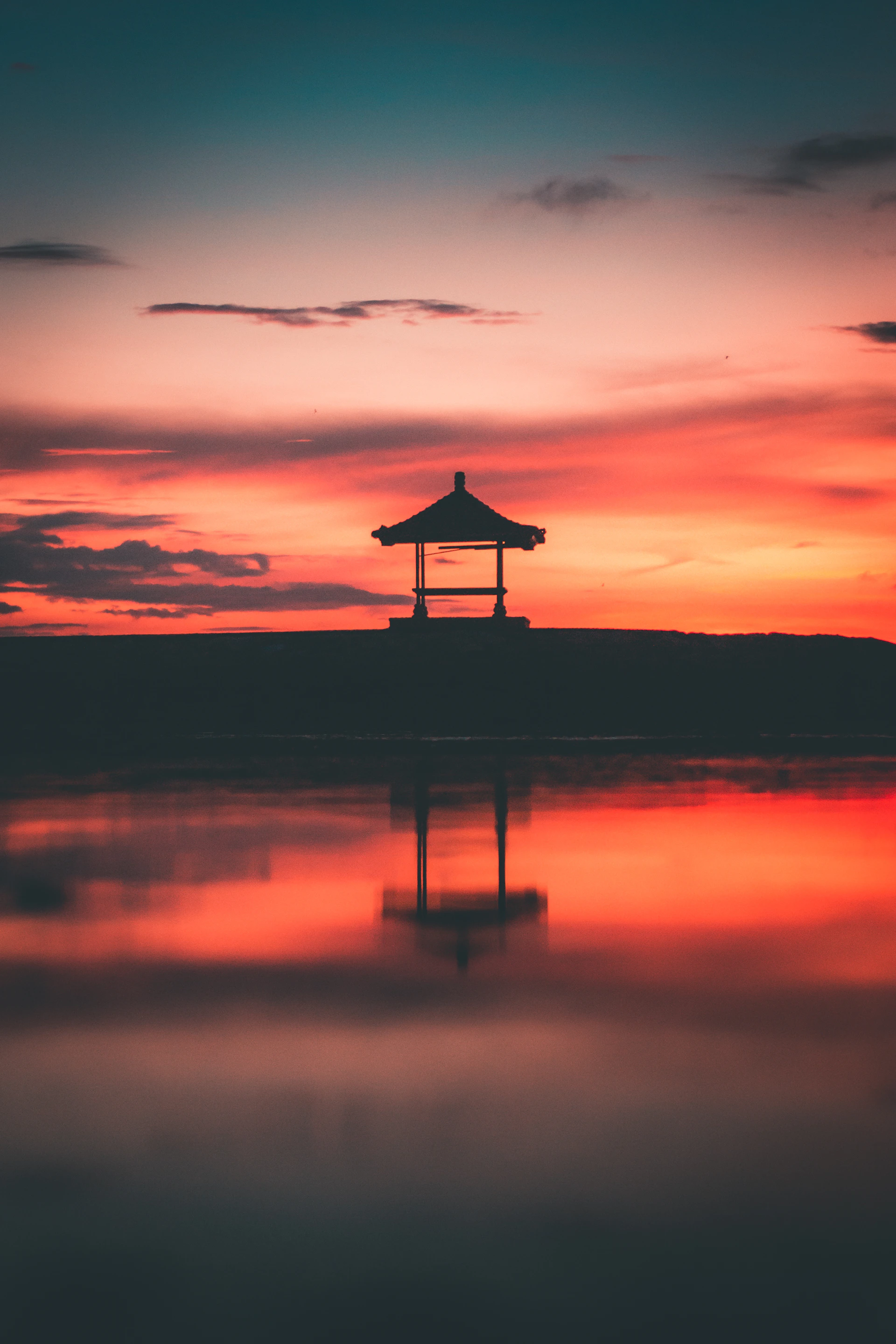 silhouette of person standing on dock during sunset