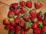 Freshly harvested strawberries scattered on a rustic cloth.