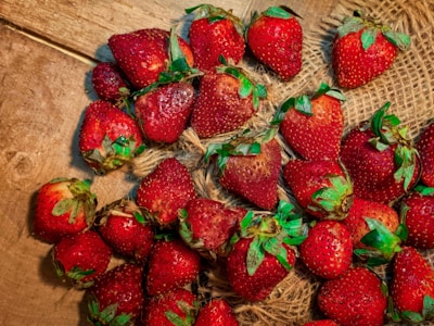 Freshly harvested strawberries scattered on a rustic cloth.