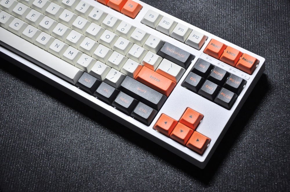 白とオレンジのコンピュータキーボード