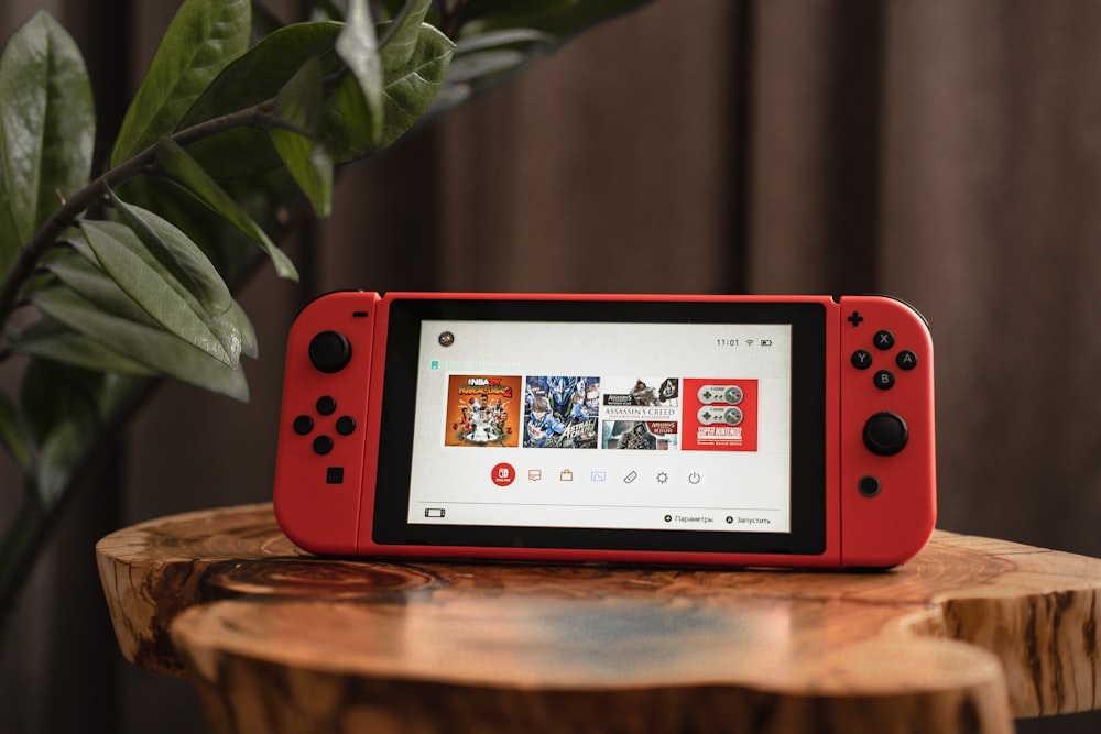 red nintendo switch on brown wooden table