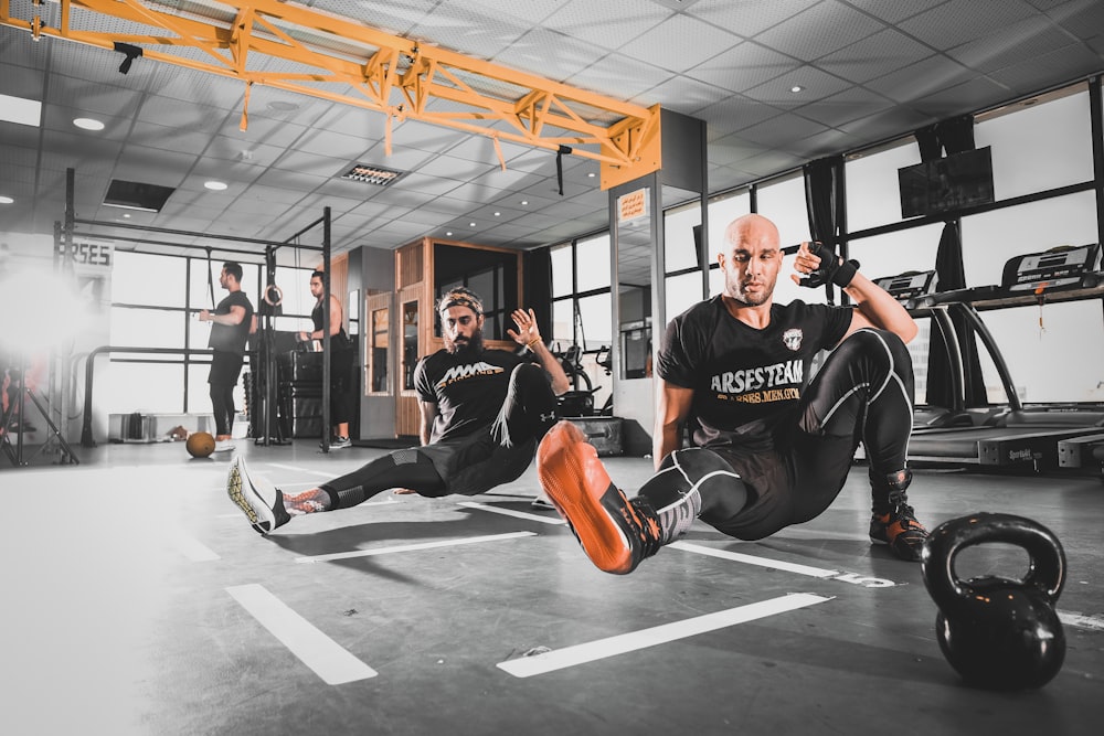 man in black crew neck t-shirt and black pants sitting on black floor