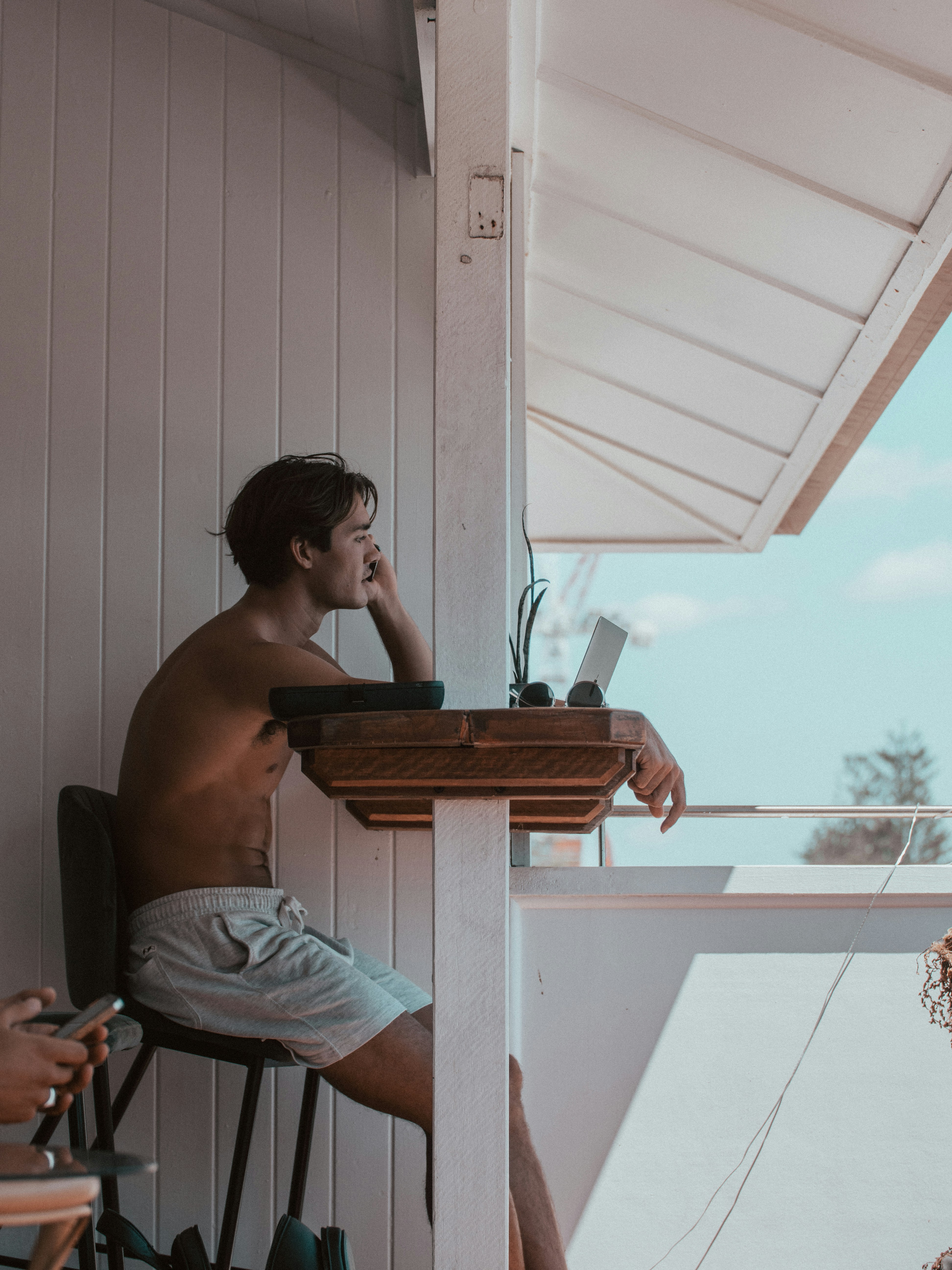 homem em shorts cinza sentado na cadeira