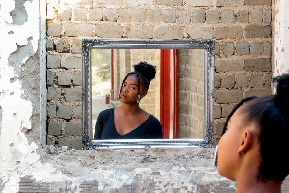 woman in black tank top standing beside window