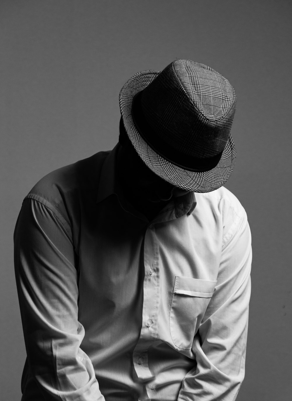 grayscale photo of man wearing hat and button up shirt