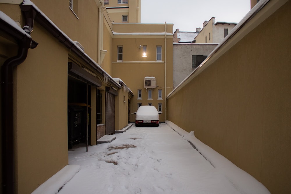 white car parked beside yellow concrete building during daytime