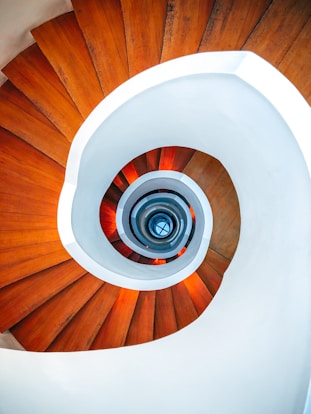 brown wooden spiral staircase with white round ceiling