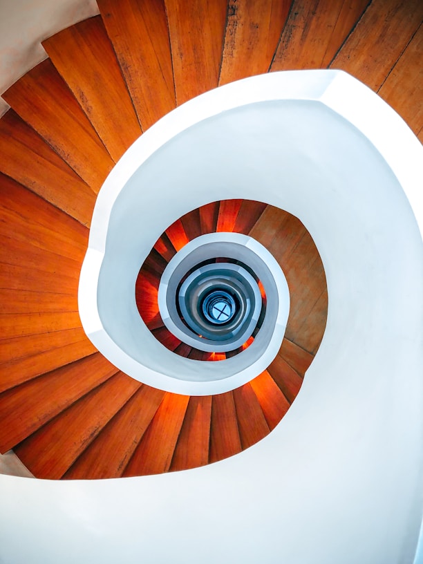 brown wooden spiral staircase with white round ceiling