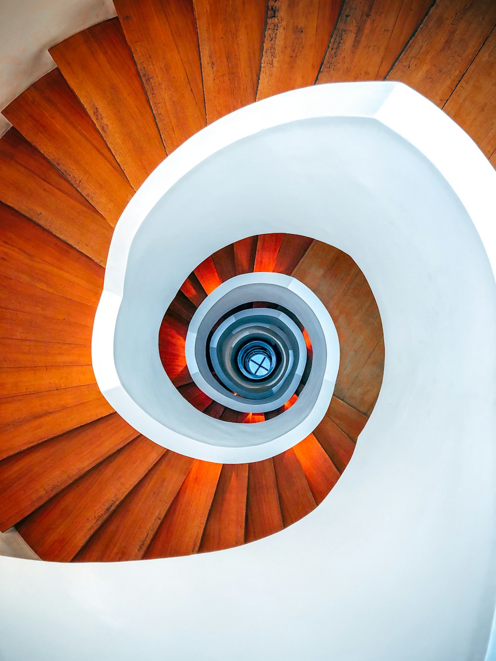 Escalera de caracol de madera marrón con techo redondo blanco