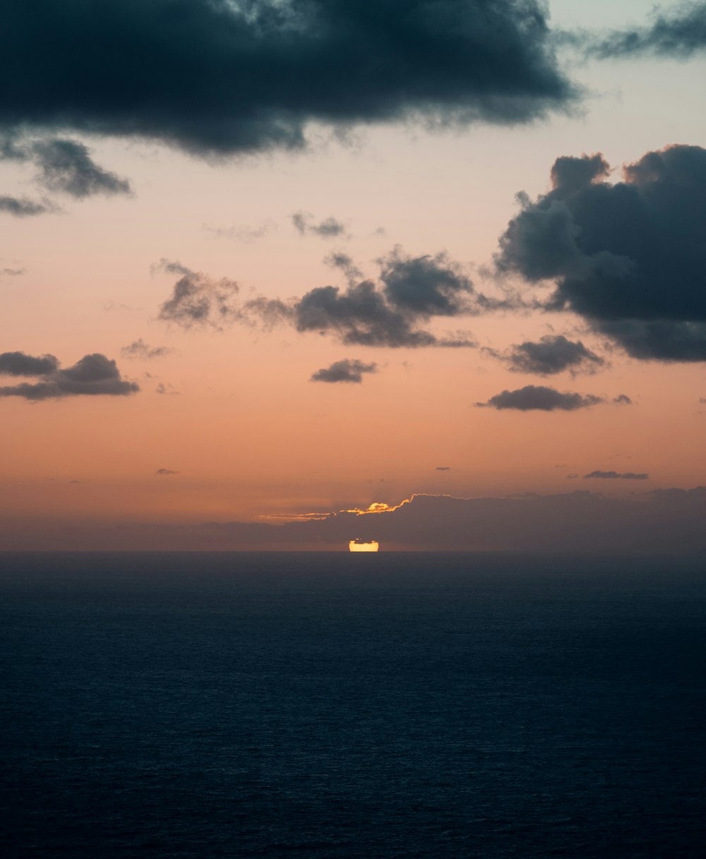 body of water under cloudy sky during sunset