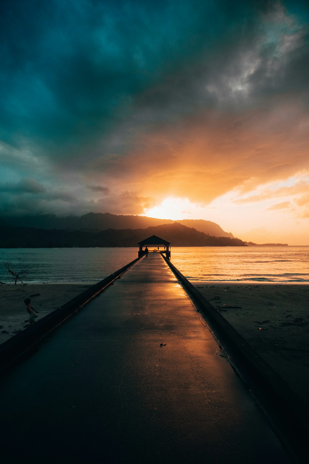 brown wooden dock on sea during sunset