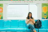 Happy passenger arriving at destination, smiling while checking the Me Leva Aí app on their phone with blue and yellow ochre colors.
