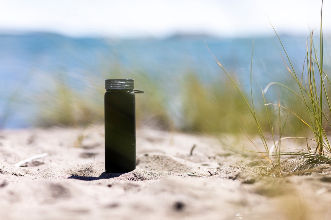 green and silver steel container on brown sand during daytime