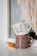 white and black ceramic mug on brown wooden table