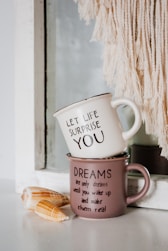 white and black ceramic mug on brown wooden table
